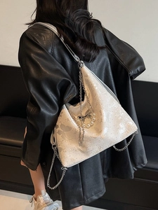 White denim tote bag with butterfly prints, pearl chain, and glitter texture on a shoulder