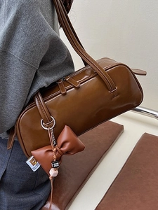Brown leather cylinder shoulder bag with bow detail for women in 2025 summer fashion