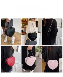 Detail view of heart-shaped crossbody bags with embossed letters in black, red, and pink