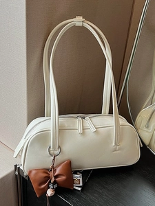 Creamy white Boston shoulder bag with leather bow pendant and long handles in chic setting