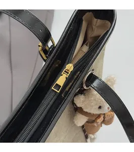 Detail of smooth zipper closure on beige canvas tote with cute plush bear charm