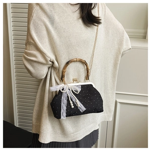 Close-up of vintage polka dot handbag with bamboo handle and lace bow detail