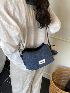 Blue denim crossbody bag with logo patch and plush bear charm for daily casual style