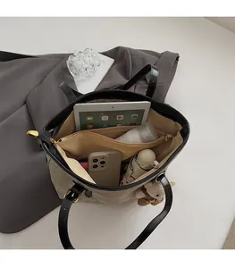 Macro view of canvas tote bag interior showing large capacity and multi-compartment storage