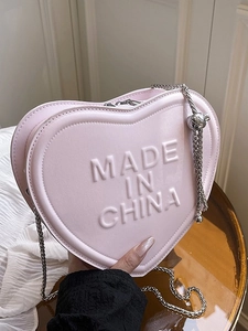 Stylish pink heart-shaped crossbody bag with embossed lettering and silver chain strap