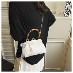 Detailed back view of white lace crossbody bag with bamboo handle and pearl accents
