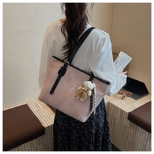 Pink embossed leather tote bag featuring a cute teddy bear charm on the shoulder strap