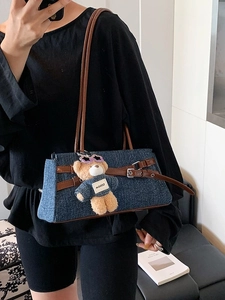 Blue denim tote bag with brown leather straps and a cute teddy bear charm