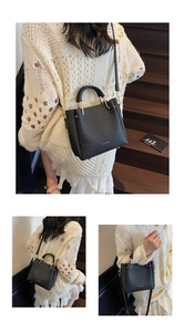Close-up of black litchi pattern leather tote bag with gold logo and hardware accents