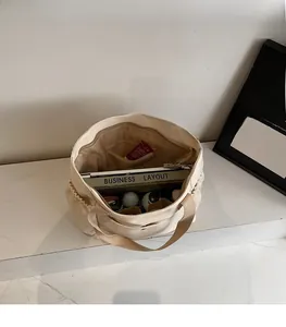 Spacious interior of beige nylon tote bag showing laptop and zippered pocket