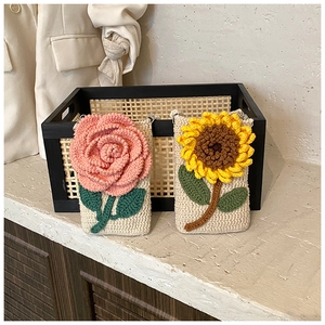 Gros plan détaillé de sacs bandoulière faits main au crochet avec tournesol et rose
