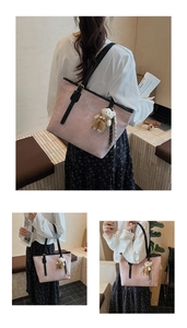 Pink embossed tote bag featuring a cute teddy bear pendant and adjustable black shoulder straps