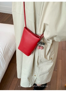 Red lychee grain leather crossbody phone bag with cherry pendant and adjustable strap