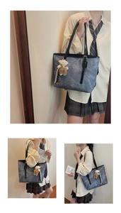 Detail of blue marble texture tote bag with black straps and a cute bear charm