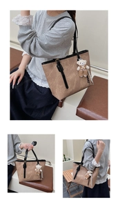 Detail of vintage brown embossed tote bag featuring a cute white bear fashion pendant