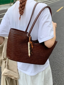 Dark brown woven leather tote bag with elegant wooden bead charm for women