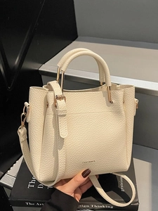 Minimalist beige pebble leather tote bag with top handles and adjustable strap