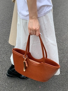 Caramel brown woven tote bag with top handles and colorful beaded charm for daily wear