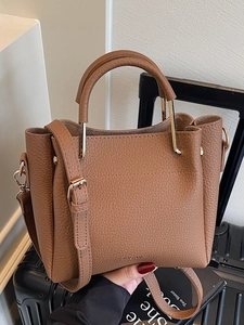 Brown lychee leather tote bag with round handles and adjustable strap for women