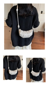 Detailed view of white crescent bag with silver studs and decorative knotted shoulder strap