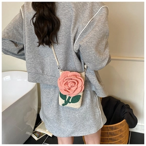Détail d'un sac bandoulière au crochet avec rose 3D rose et feuilles vertes brodées