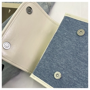 Detail of metal magnetic buckles on casual denim and PU leather patchwork backpack
