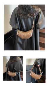 Detail of brown crescent bag with silver rivets and knotted leather strap on a model