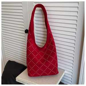 Close-up of red suede tote bag with silver studs in a diamond pattern