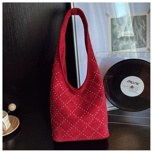 Detail of red suede hobo bag with silver metallic studs in a diamond lattice pattern