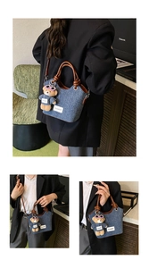 Detail view of denim bucket bag with leather handles and a plush bear pendant charm