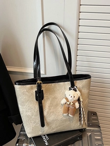 Beige embossed tote bag with cartoon patterns and cute plush bear charm decoration