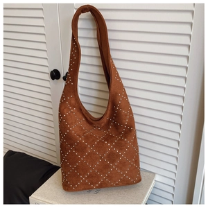 Macro detail of brown suede shoulder bag with silver stud rivets in diamond pattern
