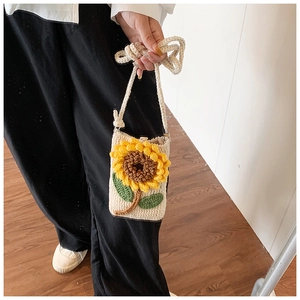 Gros plan d'un mini sac en crochet avec une fleur de tournesol en 3D et une bandoulière