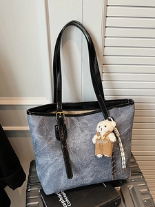 Vintage blue embossed tote bag with teddy bear charm and black glossy handles