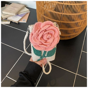 Détail du sac à bandoulière en tricot crème avec une rose 3D rose et feuilles