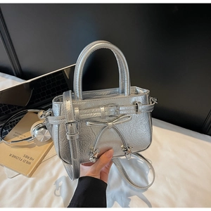 Détail du mini sac argenté plissé avec nœud, pendentif étoile et fine bandoulière