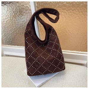 Close-up of brown suede shoulder bag with silver studs and quilted diamond pattern