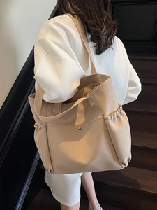 Large khaki canvas tote bag with side pockets and shoulder straps for daily commuting