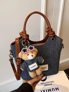 Contrast denim bucket bag with brown leather knotted handle and bear charm for women