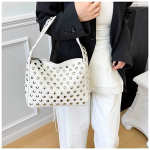 Close-up of white crossbody bag with silver rivet details and textured leather