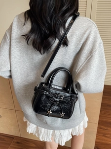 Petit sac à bandoulière en cuir verni noir brillant avec breloques étoiles et nœud