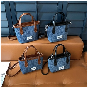 Collection of mini denim bucket bags with leather trim and adjustable straps on a sofa