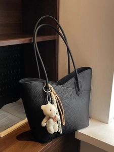 Black pebbled leather tote bag with thin straps, plush bear charm and striped silk scarf