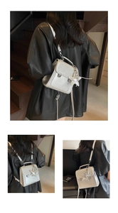 Detail of mini silver crocodile pattern backpack with star charm and metallic lock