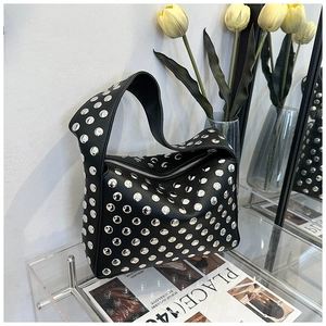 Close-up of black rivet shoulder bag featuring silver studs and textured leather finish