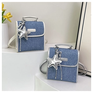 Detail of mini denim backpacks with silver star charms and fashion leather labels