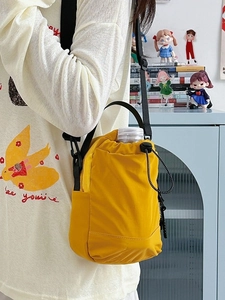 Bright yellow nylon crossbody phone bag with drawstring and adjustable strap