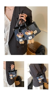 Close-up of denim bucket bag featuring a cute bear charm with purple heart sunglasses