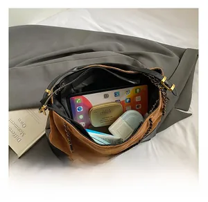 Vue intérieure du sac seau spacieux montrant tablette, cosmétiques et poche zippée
