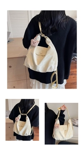 Detail of cream soft leather tote bag showing convertible straps and cute bear pendant